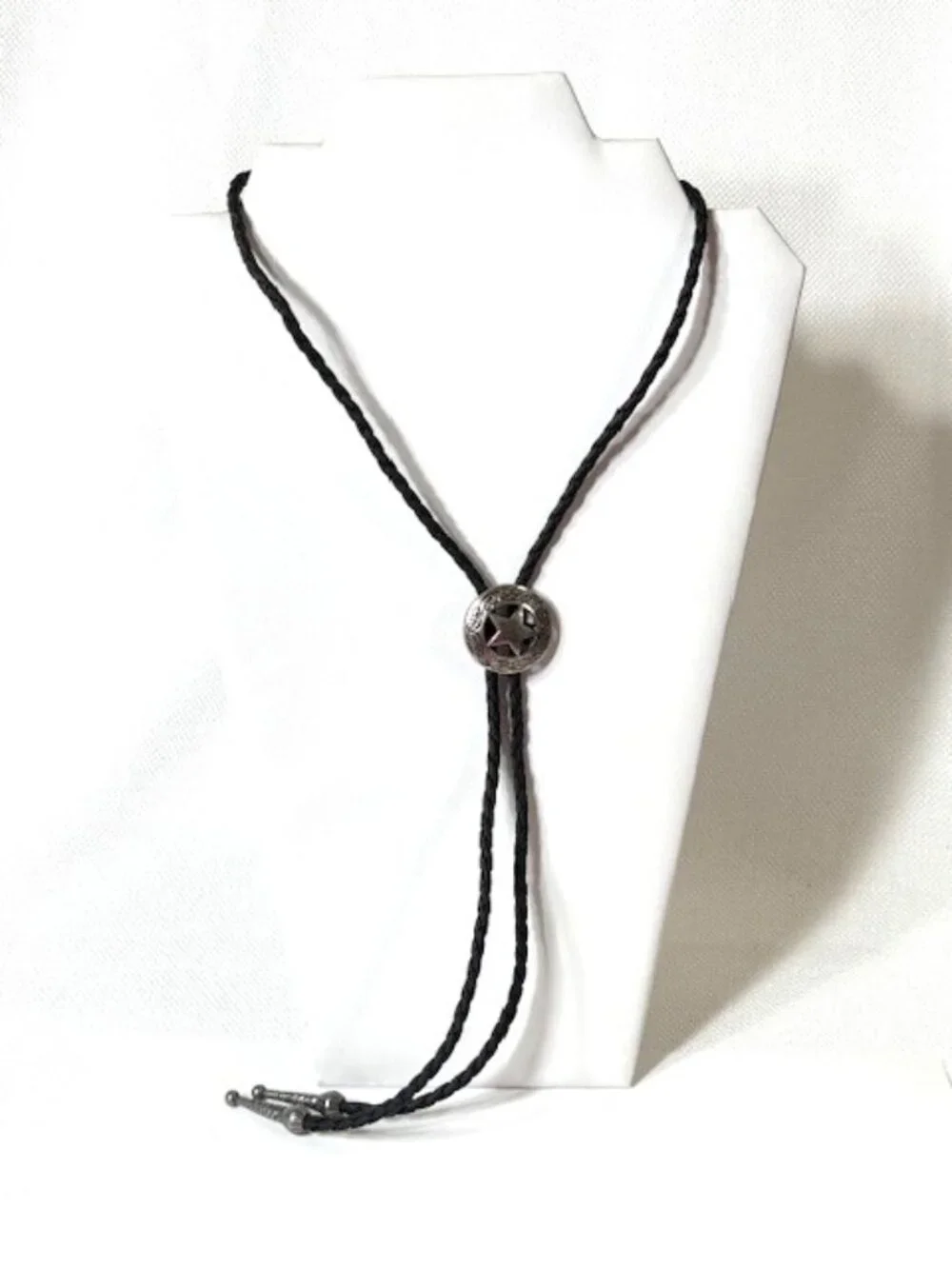 Silver-tone sheriff star and black cord western cowboy bolo tie.
